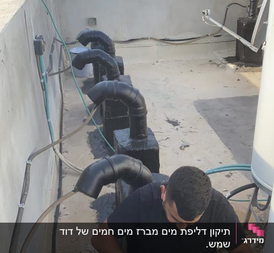אדם עובד עם כלי עבודה על צינור על גג